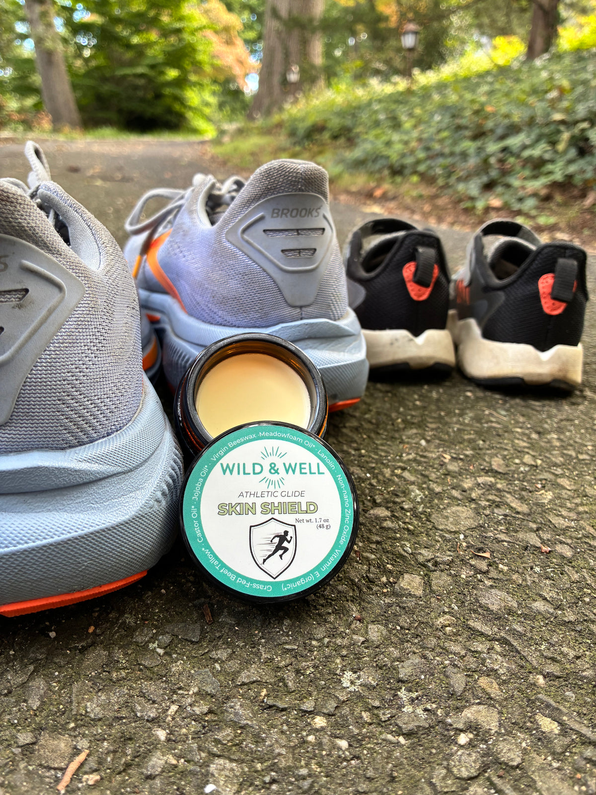 Skin Shield athletic glide balm beside running shoes outdoors